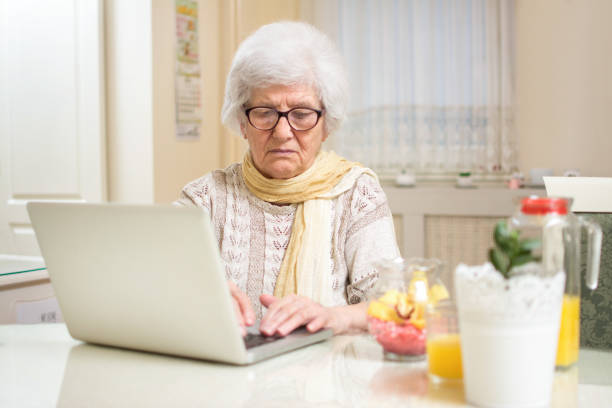 istock Elder woman using a laptop computer at home. 697604398