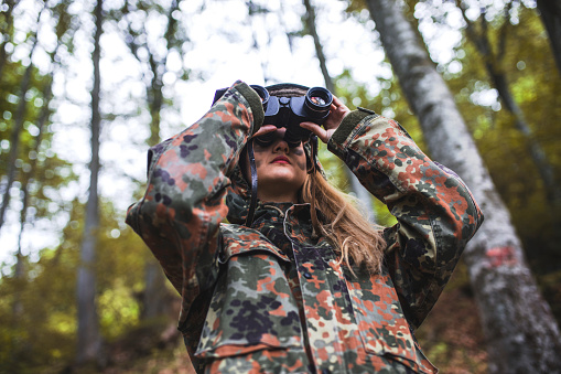 Woman patrol with binocular in forest