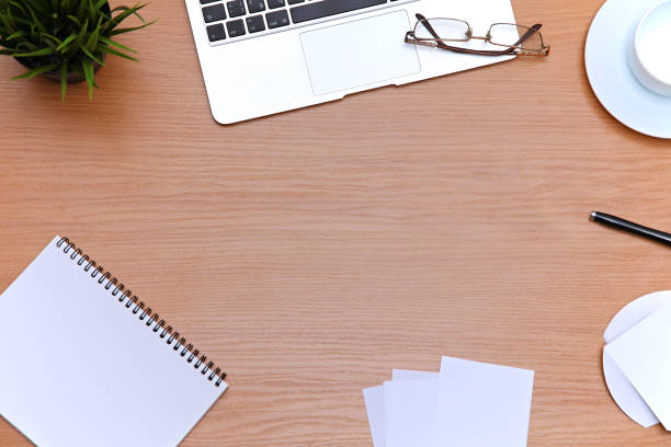 istock Office table with laptop, notepad and coffee cup. View from above with copy space 697611548