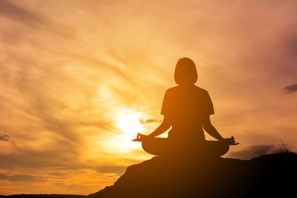 istock Woman Meditating Against Sunset Sky 697612005