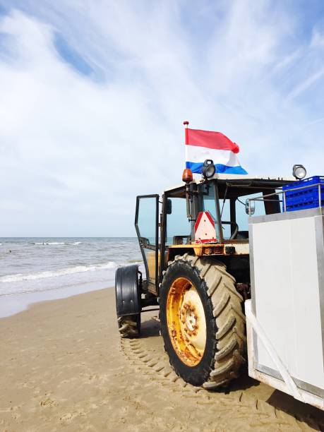 istock Tractor With Dutch Flag At Beach Against Sky 697612925