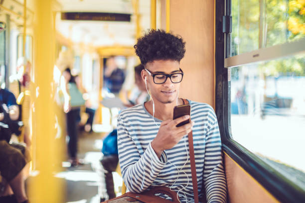 Checking messages Young man checking messages on his smart phone bus hungary stock pictures, royalty-free photos & images