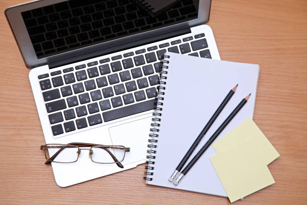 istock Office table with laptop, notepad and coffee cup. View from above with copy space 697618598