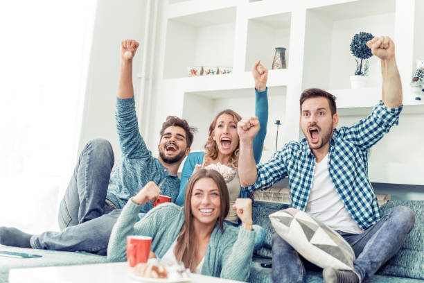 przyjaciele bawią się w domu - soccer fan sport cheering zdjęcia i obrazy z banku zdjęć