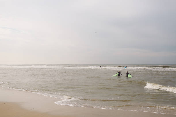 istock People Walking With Surfboards In Sea 697627613