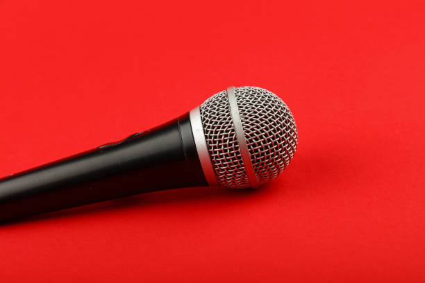 istock Close-Up Of Microphone Over Red Background 697629093