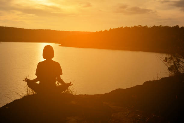 istock Woman Meditating During Sunset 697629285