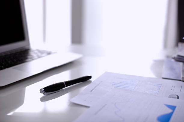 istock Office workplace with a laptop and financial documents 697639618