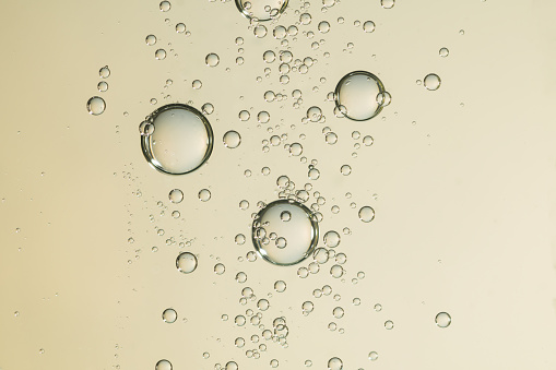 Golden air bubbles soars over a light background