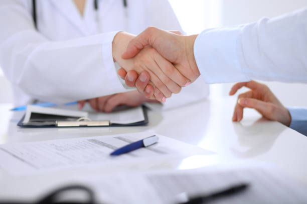 istock Doctor and patient handshaking. Hands close-up 697640804