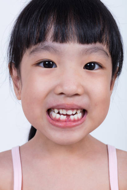 istock Asian Chinese little girl showing her missing tooth 697646806