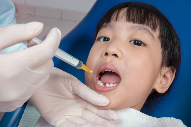 istock Asian Chinese little girl lying down for tooth extraction 697646858