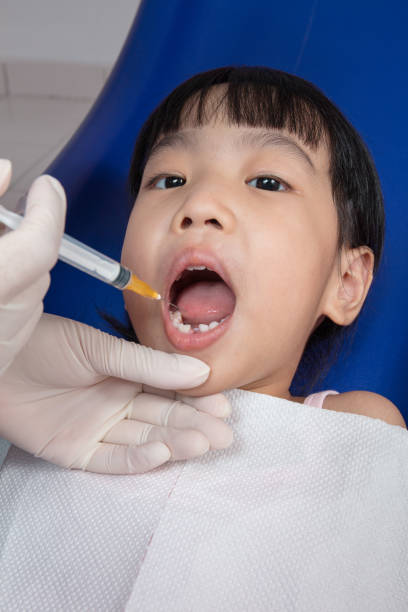 istock Asian Chinese little girl lying down for tooth extraction 697646864