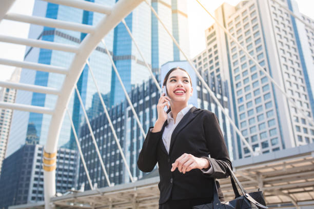 istock Young modern business woman using smart phone with copy space 697647402