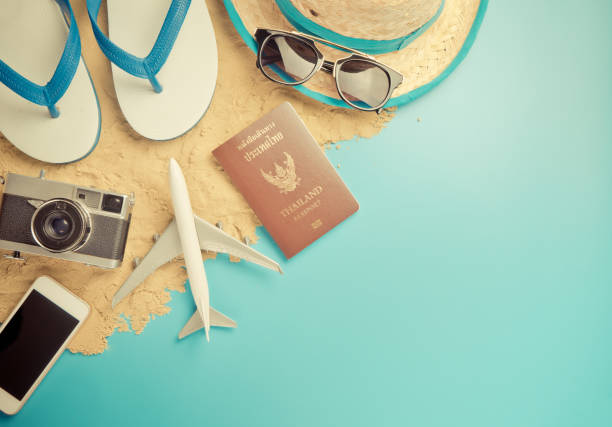 istock Summer travel accessories on sand beach with blue copy space. 697647464