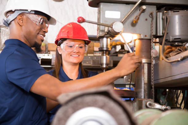istock Industrial workers use drill press equipment together in factory. 697648314