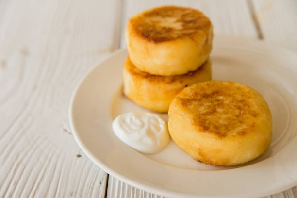 istock Cottage cheese cakes on plate with sour cream 697650820