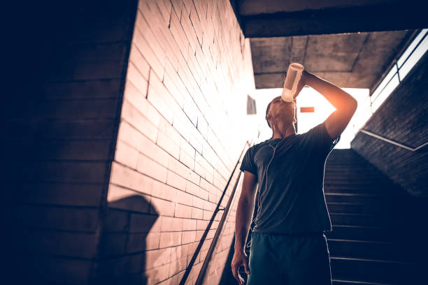 istock Young thirsty athlete drinking water after exercising 697654852