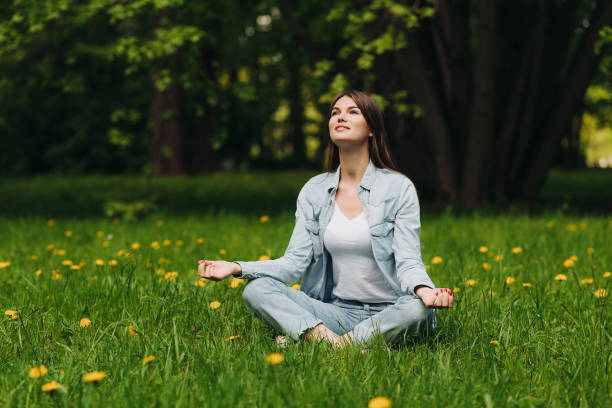 istock Young girl meditating in park 697657402