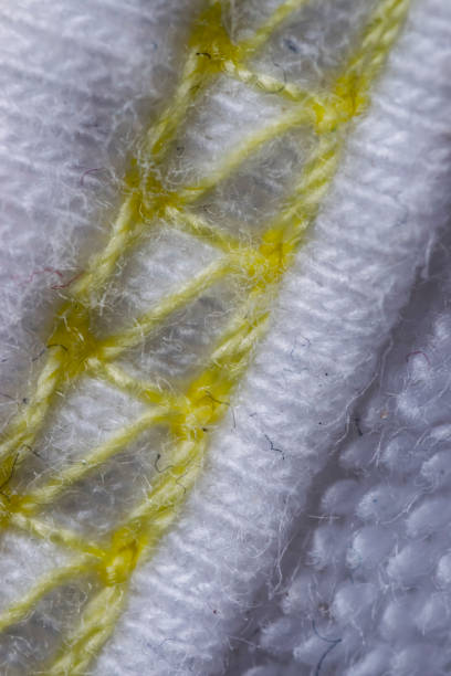 istock White and yellow stitches wool textile pattern macro, clothing 697661440