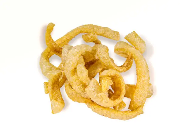 Photo of snack Thai food, fried pork crackling It's pork rind and fat isolated on white background, include with path filed.