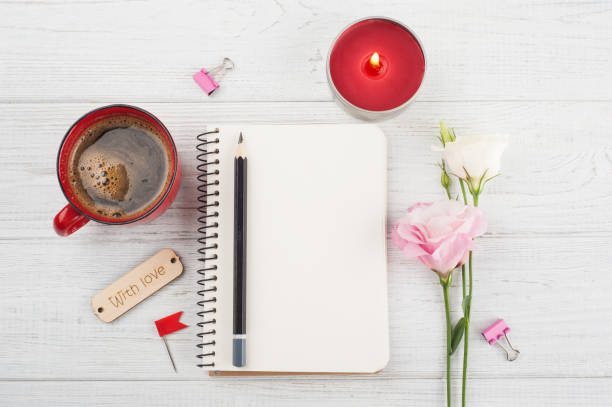 istock Blank notebook, cup of coffee, lit candle, flowers 697664380