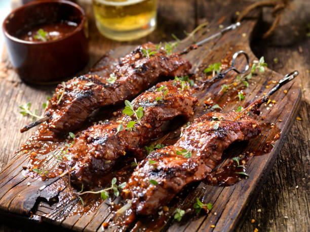 BBQ Steak Skewers Seasoned BBQ Steak Skewers with Fresh Herbs and a couple of Beers skewer photos stock pictures, royalty-free photos & images