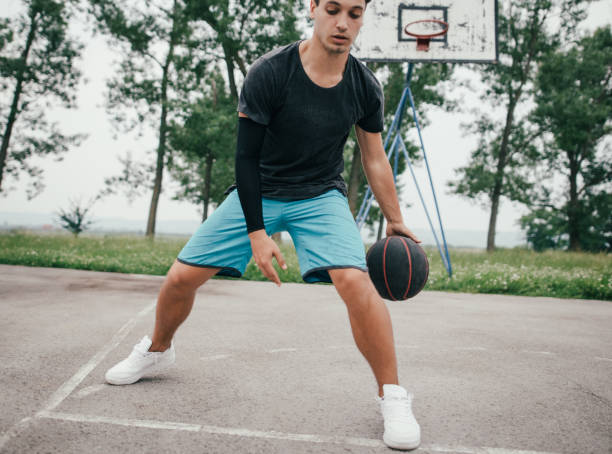 istock Street basketball player doing a slam dunk 697671296