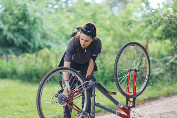 istock Young woman repairing her bicycle 697671582