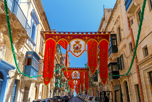 Festively decorated street with flags for the feast of St. Augustine in old town. Malta. Valletta.