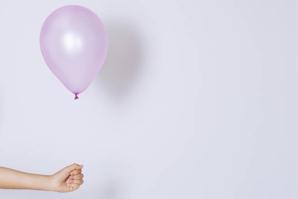 istock Womans hand holds balloons in a white background 697681884