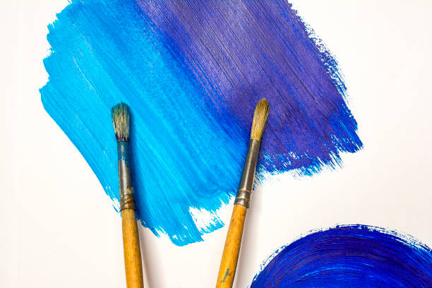 istock Two brushes on paper painted with blue spots 697688300