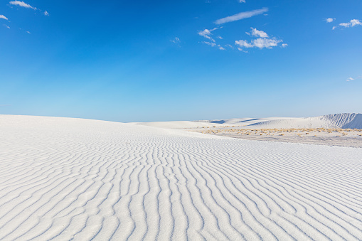 New Mexico White Sands National Monument White Rippled Desert Dunes. View over beautiful white sandy desert dunes of White Sands National Monument to the horizon under blue summer sky., New Mexico, USA.