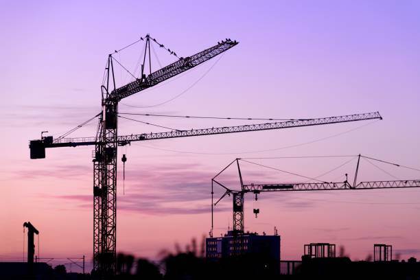 istock Crane on a construction site at night in Berlin 697695574