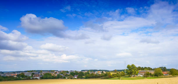 Panoramic shot of field with distant buildings and clouds, Belgium. belgium europe