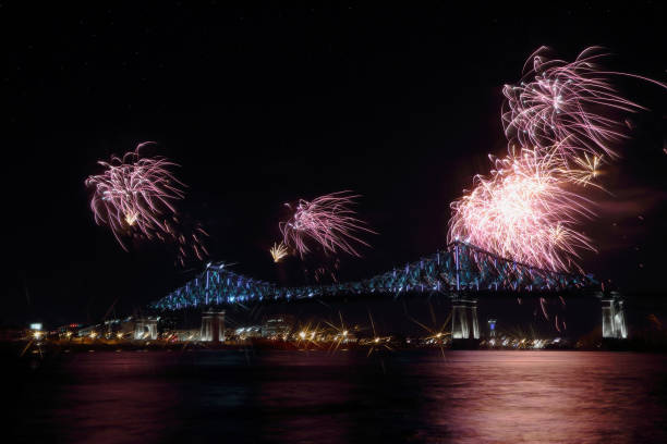 istock Colorful fireworks explode over bridge, reflection in water. Montreal’s 375th anniversary. luminous colorful interactive Jacques Cartier Bridge. Bridge panoramic colorful silhouette by night. 697696580