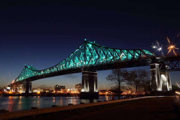 Jacques Cartier Bridge Illumination in Montreal, reflection in water. Montreal’s 375th anniversary. luminous colorful interactive Jacques Cartier Bridge. Bridge panoramic colorful silhouette by night. Jacques Cartier Bridge Illumination in Montreal, reflection in water. Montreal’s 375th anniversary. luminous colorful interactive Jacques Cartier Bridge. Bridge panoramic colorful silhouette by night. 150th anniversary stock pictures, royalty-free photos & images