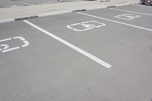 Disabled parking sign on asphalt. handicapped sign parking spot. Asphalt painted parking lot sign for people with wheelchair. Parking space area for persons with handicap outside on street, image