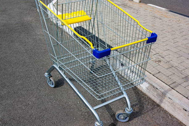 istock Empty yellow blue silver shopping cart against grey background 697712412