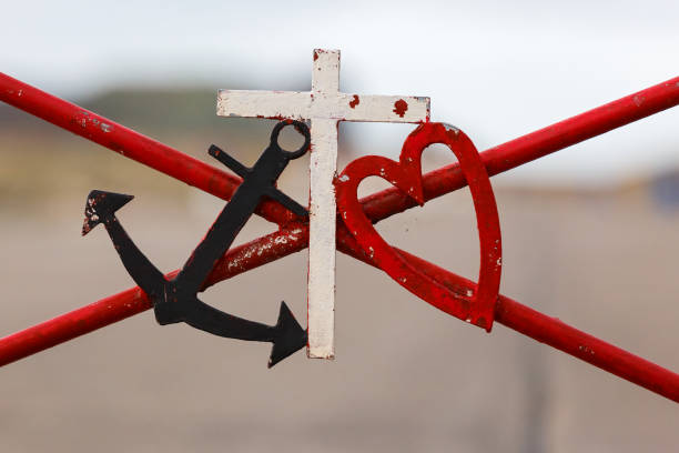 Symbolic black marine anchor red heart and white cross