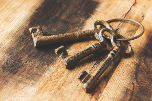 istock Three old (vintage) keys on a wooden background. 697718942