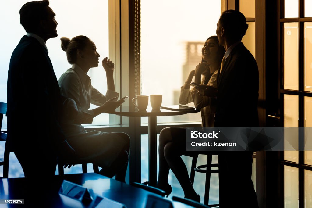 Office employees having coffee break and talking Group of office employees having coffee break and talking about business, filtered image India Stock Photo