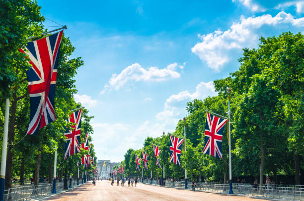 Tourists on The Mall walking towards Buckingham Palace British flags line the famous promenade to mark the monarch’s birthday celebrations british flag photos stock pictures, royalty-free photos & images