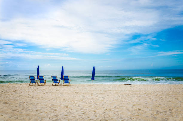 Tropical white sand beach scene with beach chairs and umbrellas.  Scenic tourist travel destination location of Gulf Coast beaches.