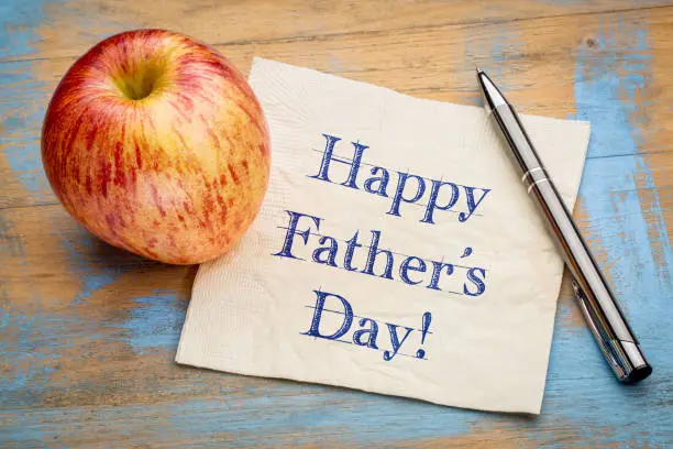 happy father's day - handwriting on a napkin with apple