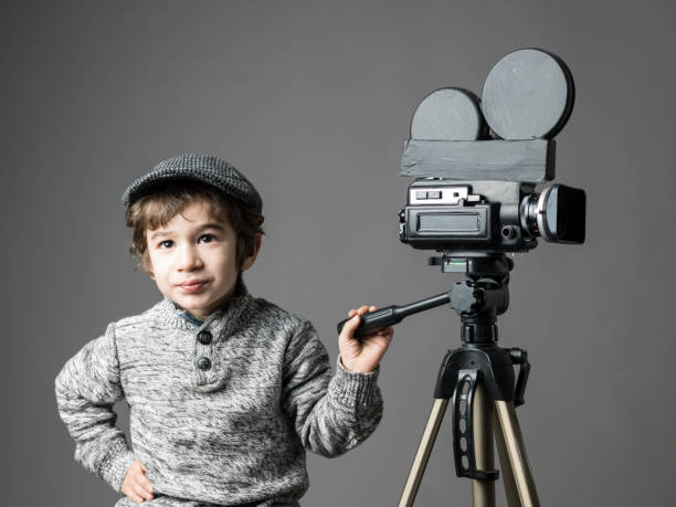istock Little Boy Wearing Flat Cap Posing With Home Modified Video Camera 697747364
