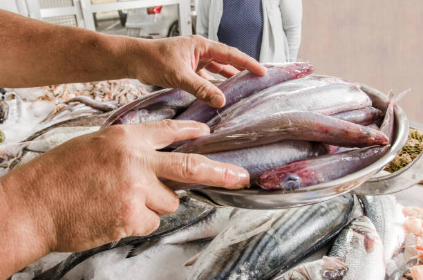 istock The fishmonger is weighing the fish on a balance for a client 697753926
