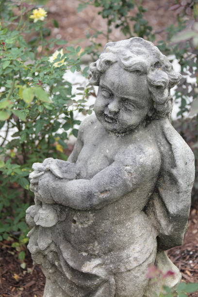 istock Antique statue in roses flowerbed. 697756334