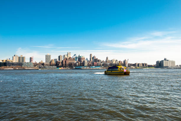 Water Taxi carries passengers on the move on East River against Brooklyn view in New York City, NY, USA Water Taxi carries passengers on the move on East River against Brooklyn view in New York City, NY, USA. Horizontal composition. Image taken with Nikon D800 and developed from Raw format. Yellow water taxi moves over river. watertaxi stock pictures, royalty-free photos & images