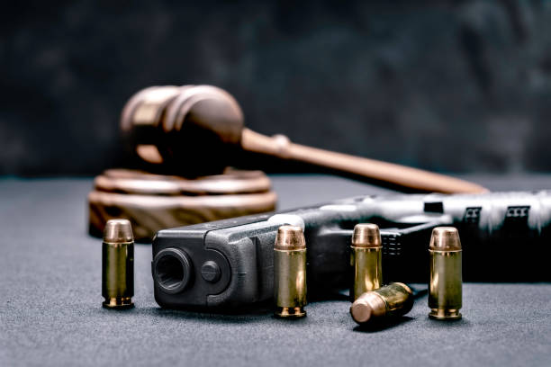 Gavel and gun rights A handgun with bullets symbolizing gun rights while framed with a judge's gavel and block. gun laws stock pictures, royalty-free photos & images